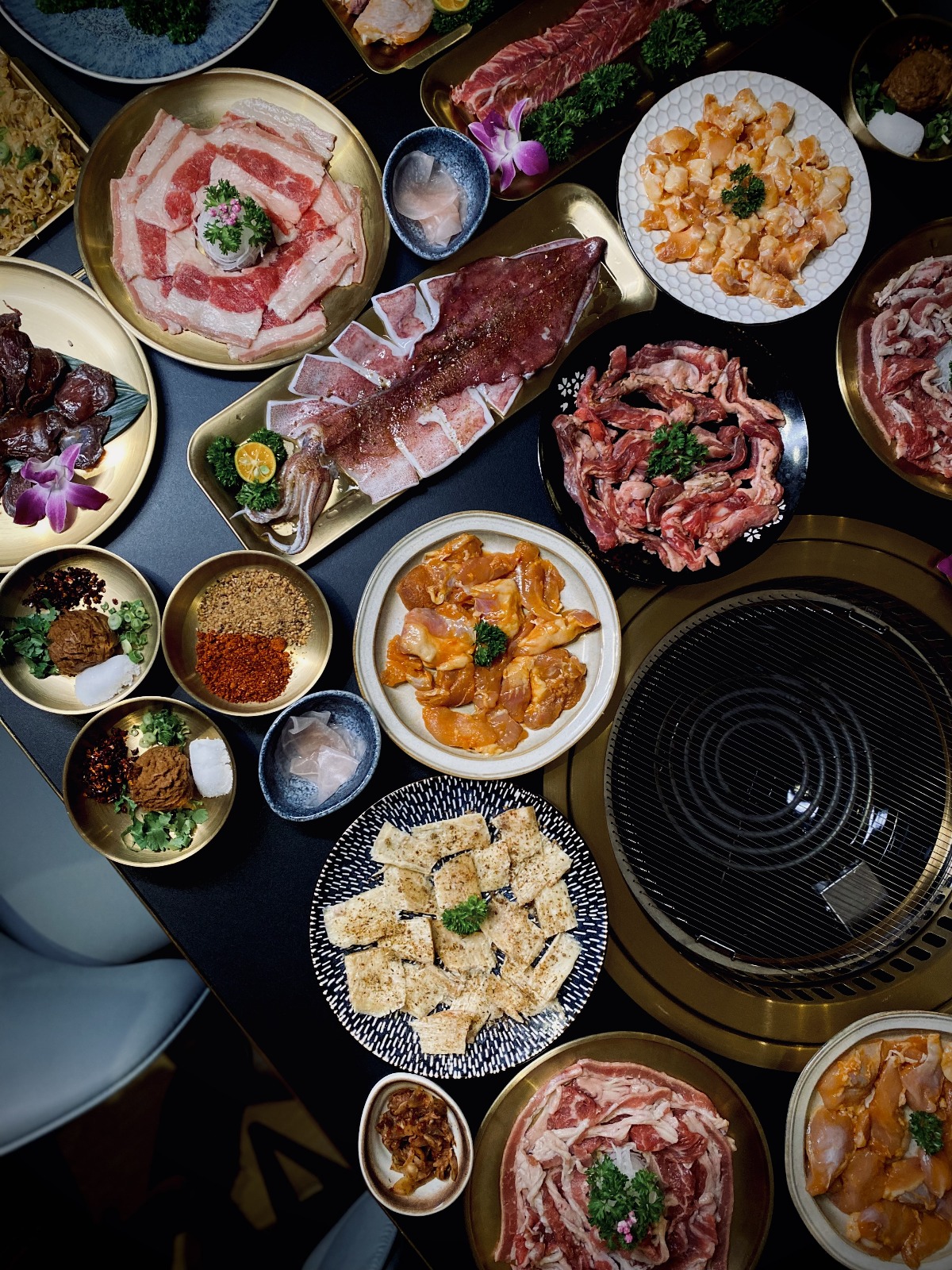 Overhead view of a grand charcoal BBQ spread
